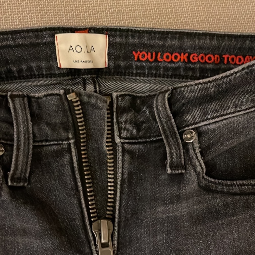 Stylish, dark gray jeans, with a blue zipper in front